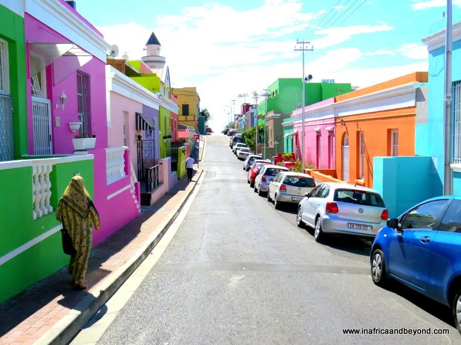 Woman walking between colourful houses in Bo Kaap, Cape Town