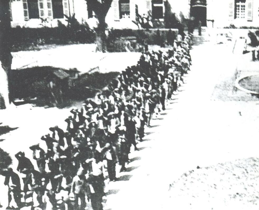 Photographie prise par un gardien montrant la livraison aux nazis par les autorités françaises de Vichy de plus de 1 000 résistants emprisonnés dans la centrale d'Eysses. Les détenus, mains sur la tête, traversent en colonne la cour d'honneur de la prison, le 30 mai 1944.