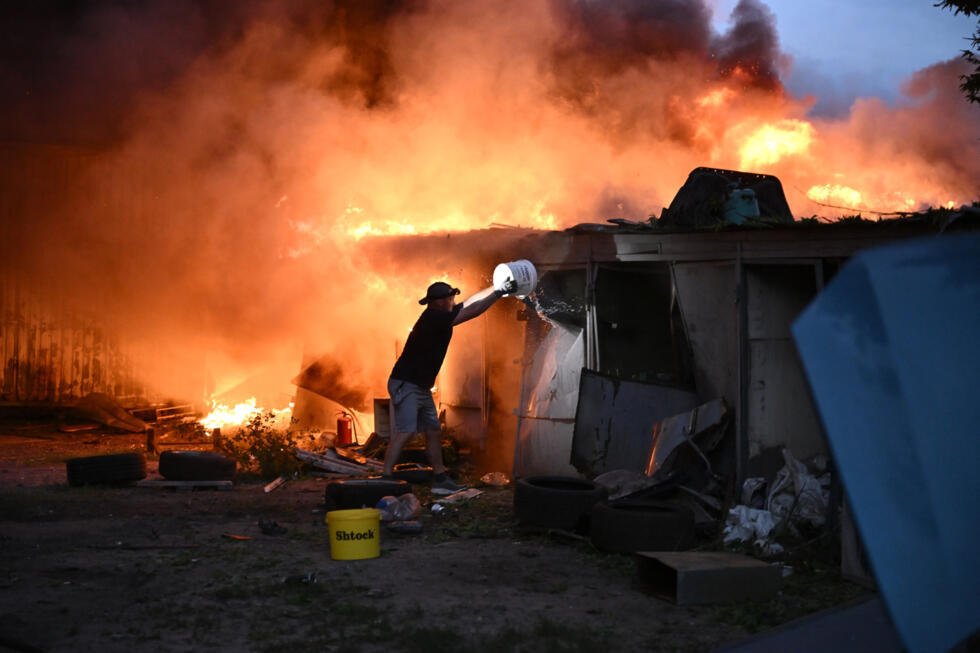Un habitant tente d'éteindre un incendie provoqué par une frappe de missile russe à Kiev, le 6 juillet 2026 en Ukraine